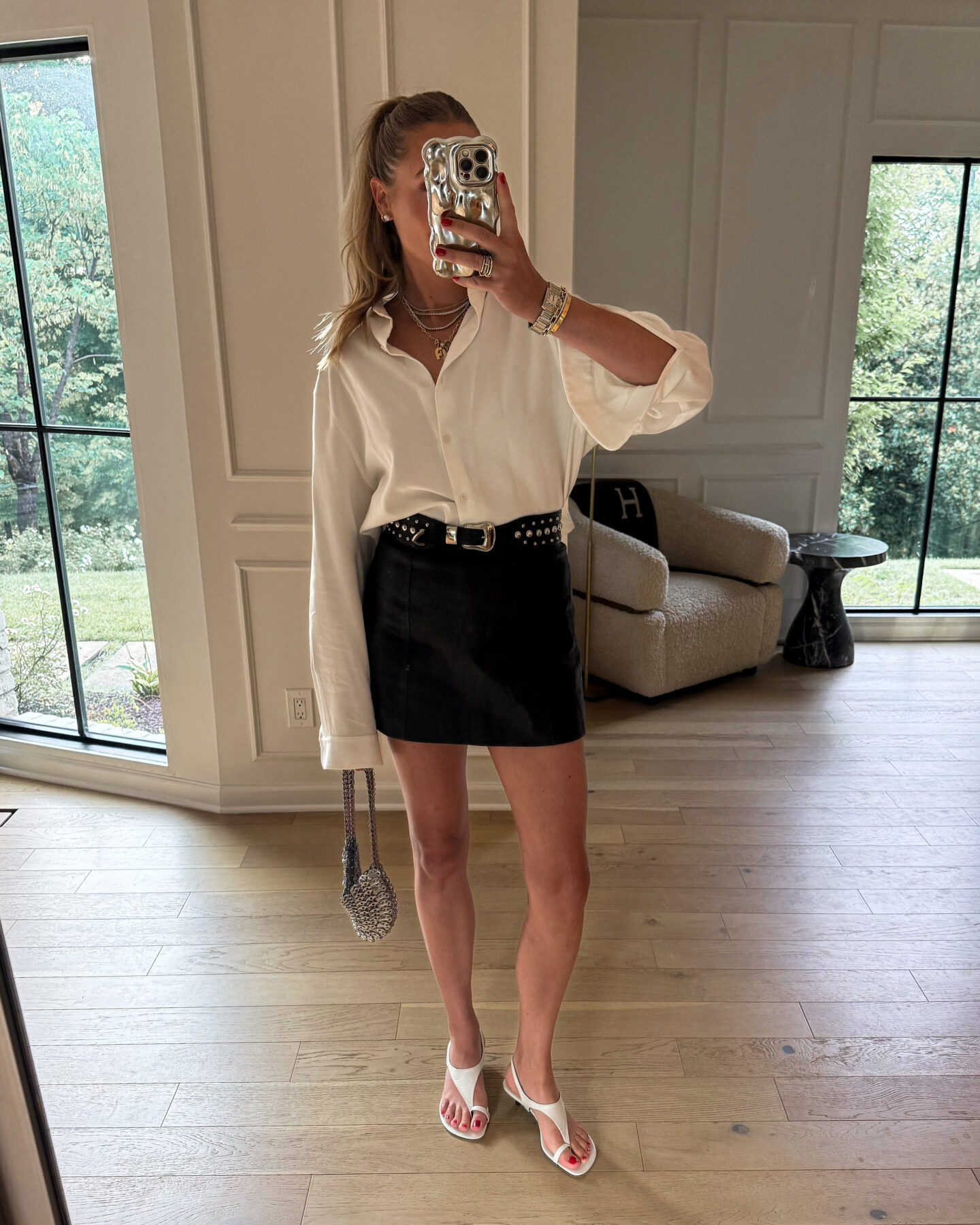 Fashion Jackson Wearing White Button Up Shirt Black Leather Mini Skirt White Heeled Sandals Paco Rabanne Silver Half Moon Handbag Womens Summer Date Night Outfit